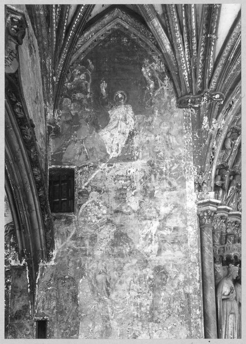 peinture monumentale du porche : Jésus Christ, entouré de saints et de saintes, bénit les infortunés de ce monde