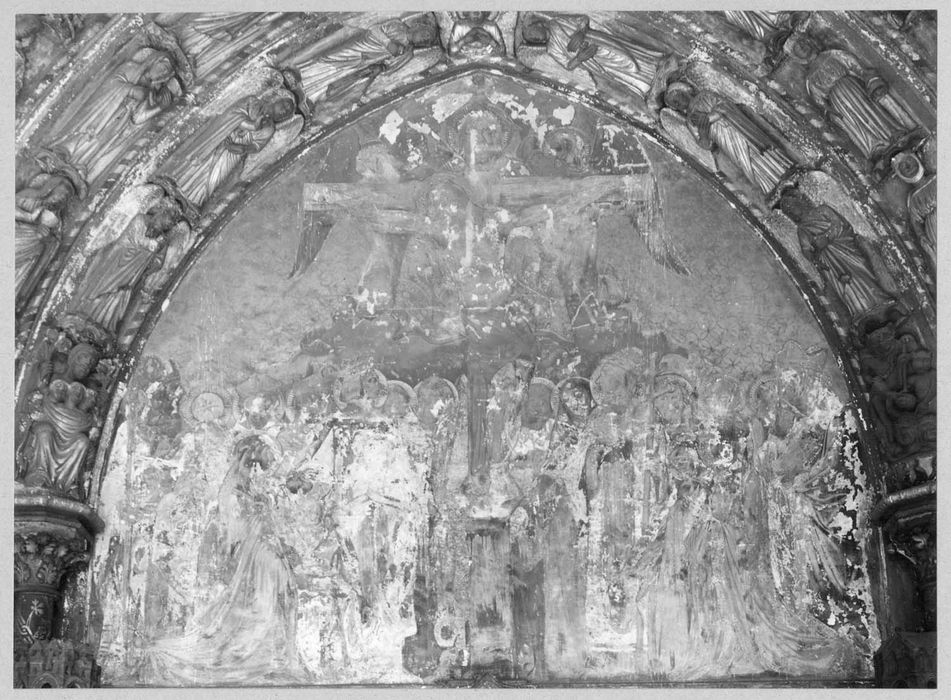 peinture monumentale du porche : Christ en croix, entouré de saints et de saintes, derrière la croix, le Père Eternel et deux anges, au-dessus la colombe symbolisant le Saint-Esprit
