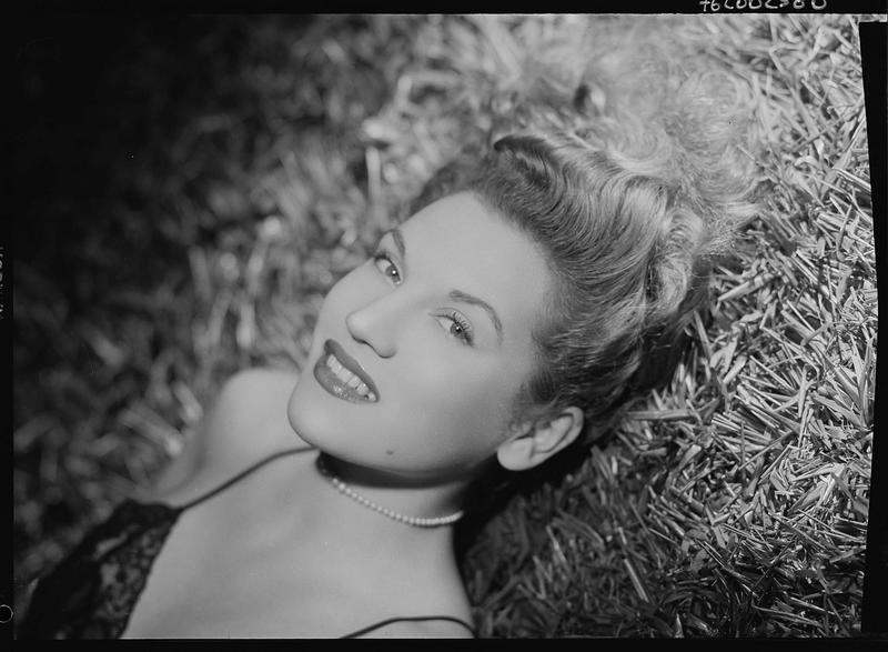 L'actrice française Joëlle Bernard allongée dans l'herbe, vue en plongée