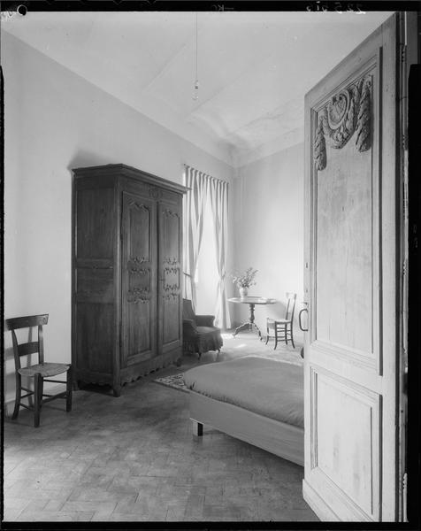 Intérieur : porte moulurée ouverte sur une chambre