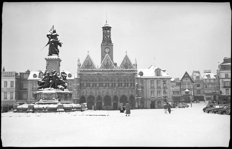 La place sous la neige : passants