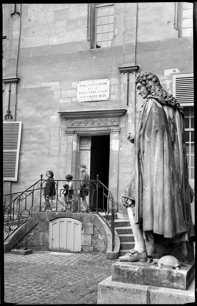 Des enfants devant l'entrée ; statue représentant le poète