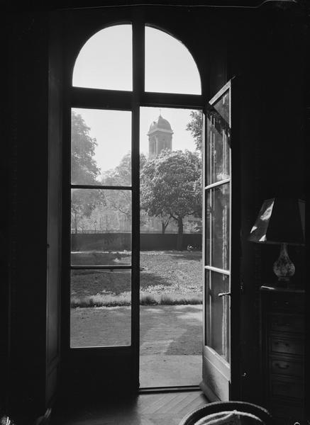 Porte fenêtre ouverte sur le jardin avec l'église Saint-François-Xavier en arrière plan