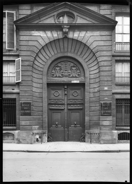 Portail principal en bois sculpté avec de part et d'autre les plaques de la Revue des Deux Mondes