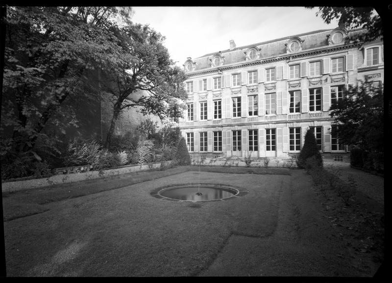 Façade côté jardin avec un bassin circulaire au premier plan