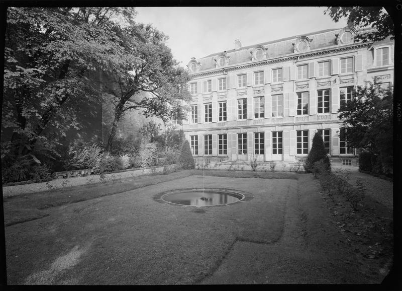 Façade côté jardin avec un bassin circulaire au premier plan