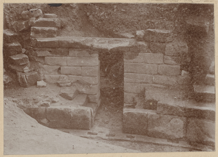 Porte nord-est donnant de l’arène dans un celle (?). Restes d’escaliers conduisant aux gradins. Podium avec bordure de grès portant des entailles semblant seulement ébauchées