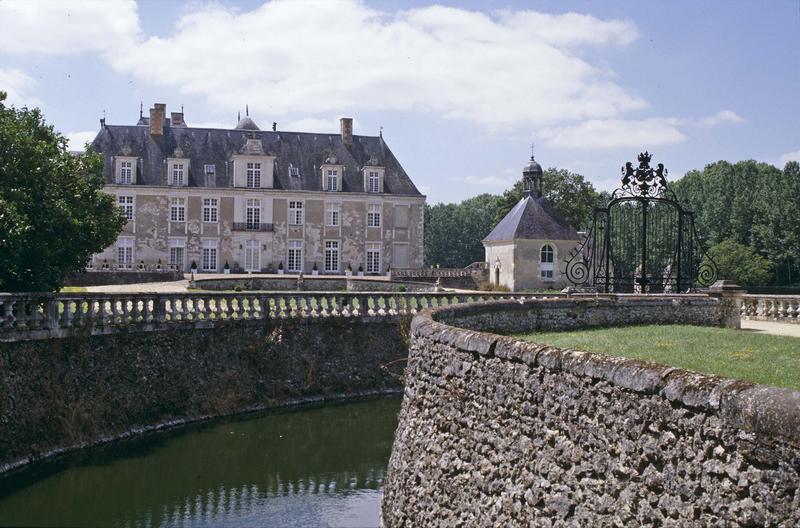 Ensemble sur cour d'honneur et grille d'entrée en fer forgé, douves au premier plan