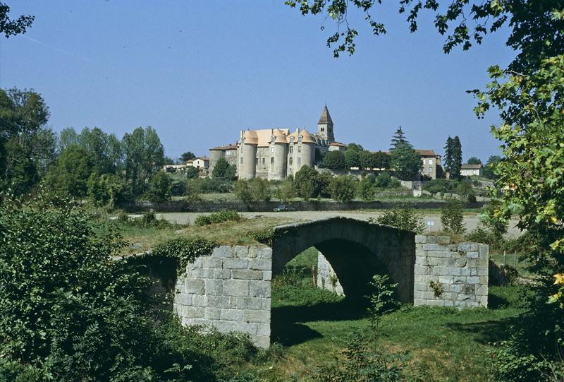 Tours du prieuré et clocher de l'église, pont ancien au premier plan