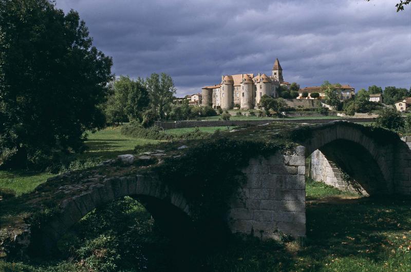 Tours du prieuré et clocher de l'église, pont ancien au premier plan