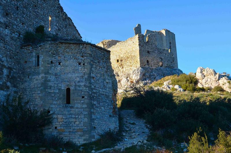 vue partielle du chevet de l'église, à l'arrière plan la château de Roquemartine