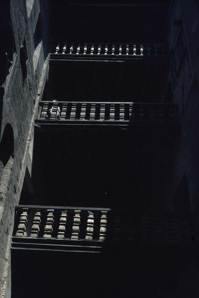 Escalier en bois à balustres sur cour intérieure