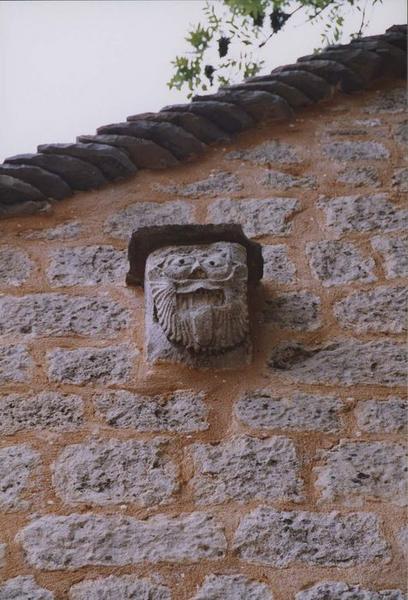 corbeau sculpté situé sur la façade sud de l'église : visage humain grimaçant