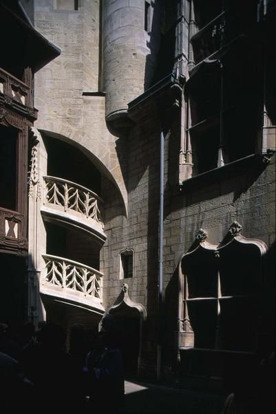 Cour intérieure : rampes sculptées d'escalier, fenestrage