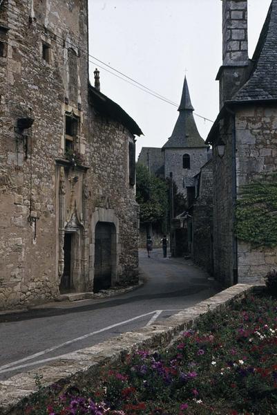 Une rue bordée de maisons anciennes vers le clocher