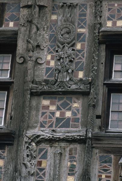 Détail de la façade à pans de bois : carreaux émaillés, statuettes, piliers sculptés