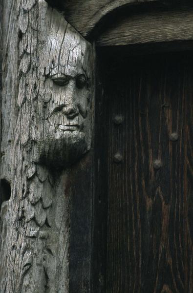 Détail de la façade à pans de bois : tête en bois près de la porte