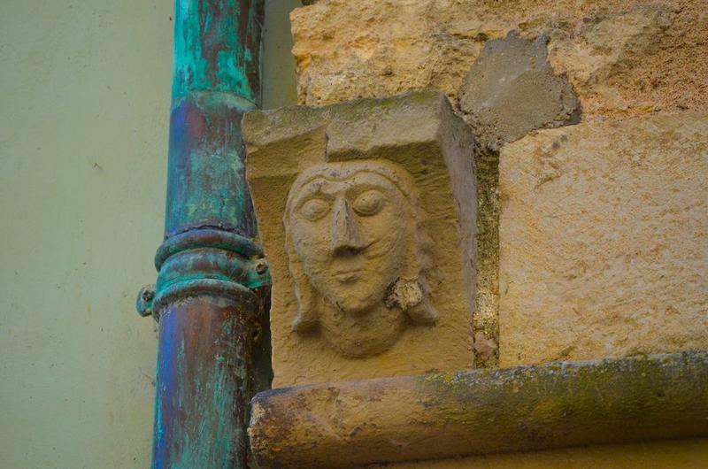 façade sur la place, détail d'un des corbeaux de pierre sculptés entre le premier et le deuxième niveau