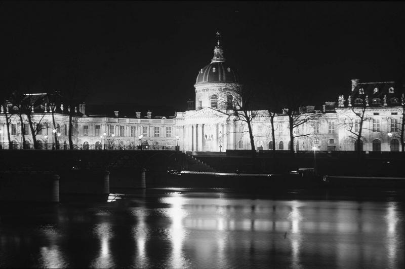 Façade sur rue de nuit, la Seine au premier plan