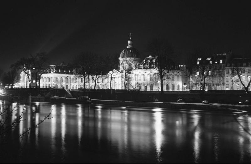 Façade sur rue de nuit, la Seine au premier plan