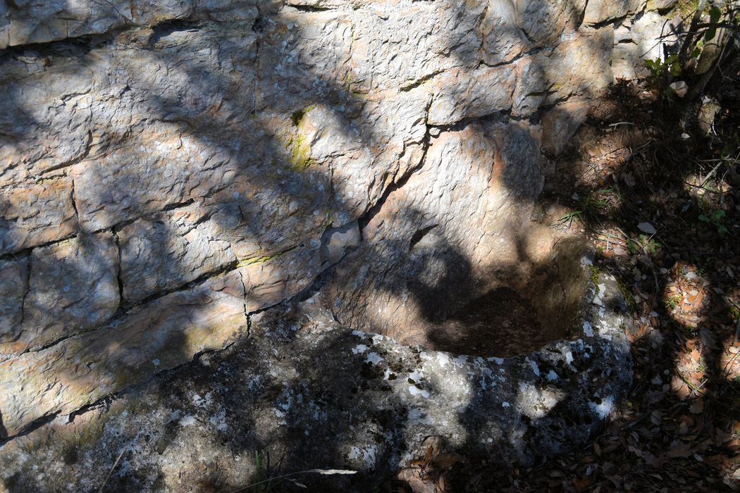 Village médiéval : Détail d'un bassin sculpté dans une maçonnerie ruiné