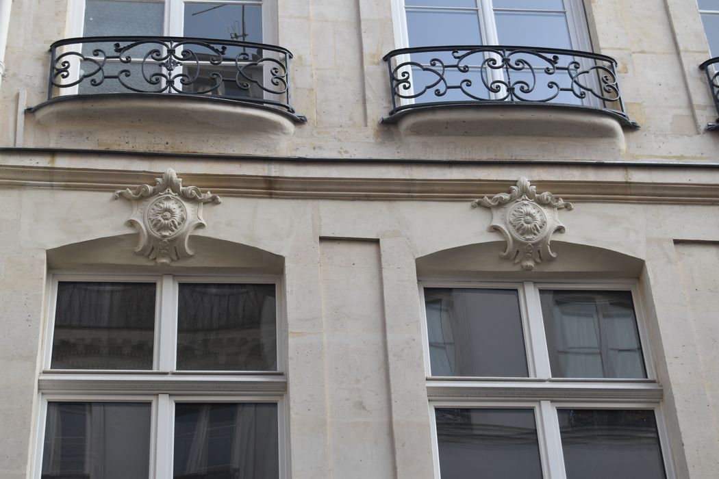 Immeuble : Façade sur la rue Saint-Honoré, détail de deux agrafes des fenêtres du 1er niveau