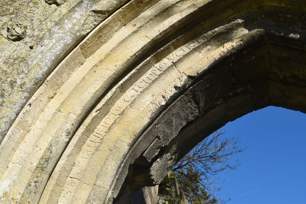 Ruines de la chapelle romane de Champlieu : Portail occidentale, vue partielle de l'inscription portée sur une des voussures