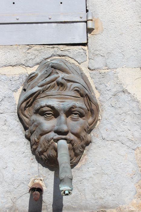 Fontaine publique, détail d'un des deux masques de fontaine