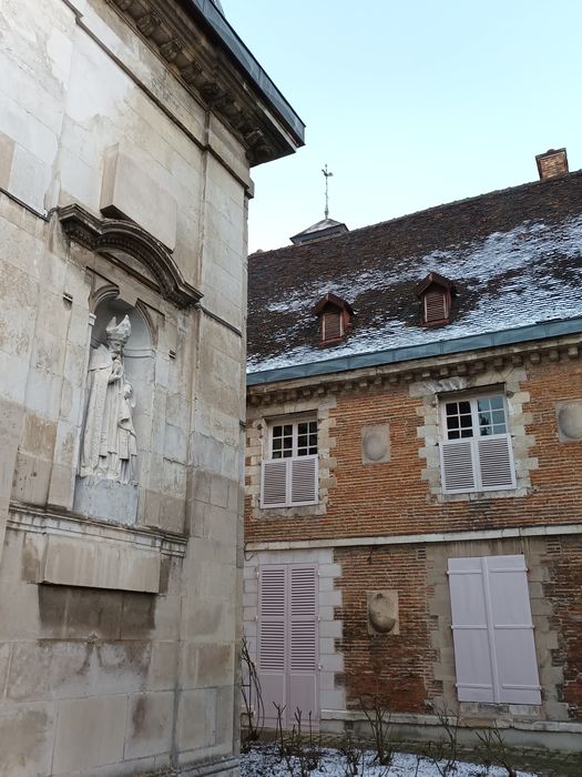 Vue partielle de la façade antérieure de la chapelle et du bâtiment bordant la cour