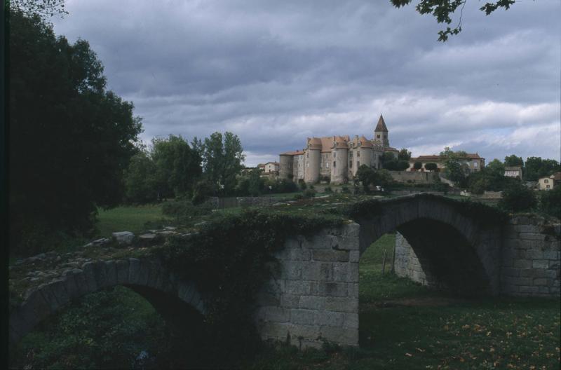 Tours du prieuré et clocher de l'église, pont ancien au premier plan