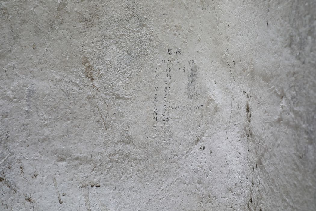 geôles des martyrs de la Résistance dans l'ancienne caserne de Lauwe, détail des inscriptions: « juillet 44 », dates du « M18 » (mardi 18 juillet) au « V28 » (vendredi 28 juillet), « alerte 12h » devant « L24 » (cellules de gauche, cellule 4)