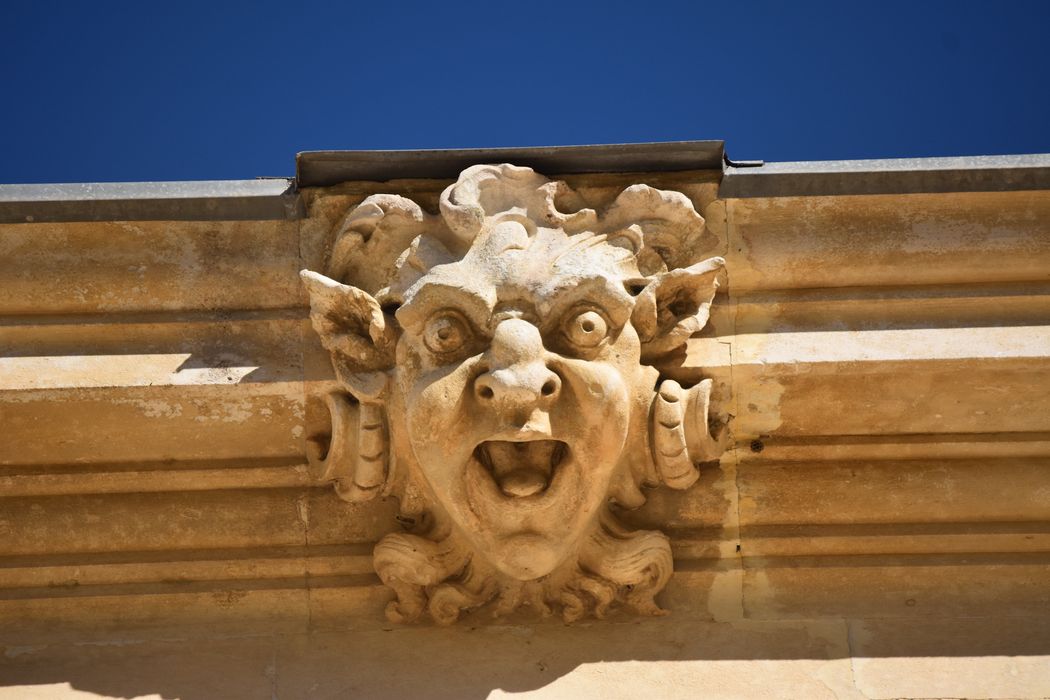 Façade sud, corniche sommitale, détail d’un masque sculpté