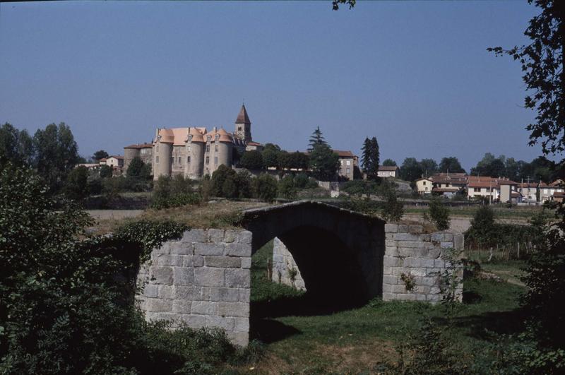 Tours du prieuré et clocher de l'église, pont ancien au premier plan