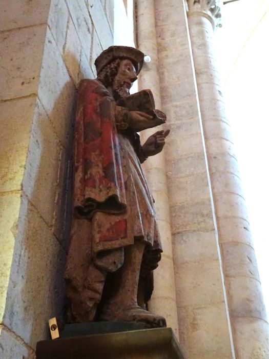 statue : Personnage en costume laïc tenant un livre, profil droit