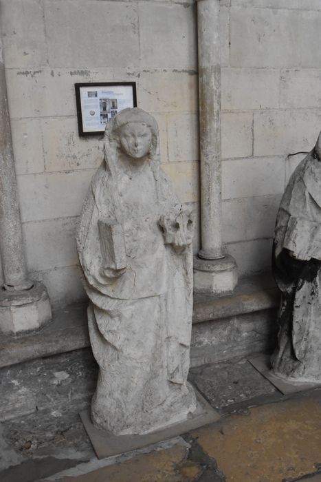 statue déposée : femme tenant une couronne et un livre