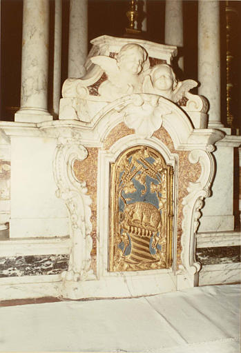 Tabernacle (autel majeur) : marbre polychrome sculpté de chérubins et volutes, porte en bois sculpté de l'agneau de l'Apocalypse, épis de blés et grappes de raisin