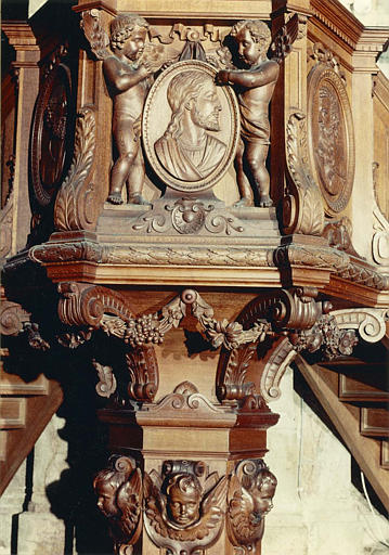 Chaire à prêcher : détail du panneau central de la tribune, médaillon sculpté en bas-relief du profil du Christ tenu par des anges, bois sculpté