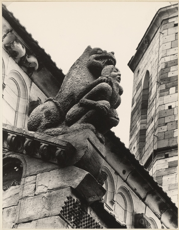 Statue d’un monstre posant ses pattes sur les épaules d’un homme accroupi