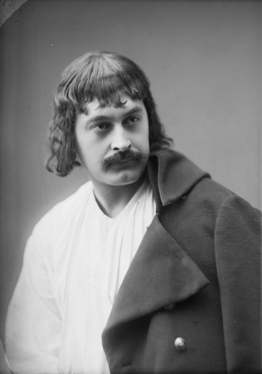 Monsieur Romain, acteur au Théâtre de la Gaîté. En buste, pose de trois quarts, la veste posée sur une épaule.