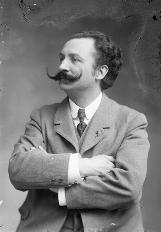 Xavier Leroux, compositeur et professeur de musique. En buste, pose de trois quarts, les bras croisés.