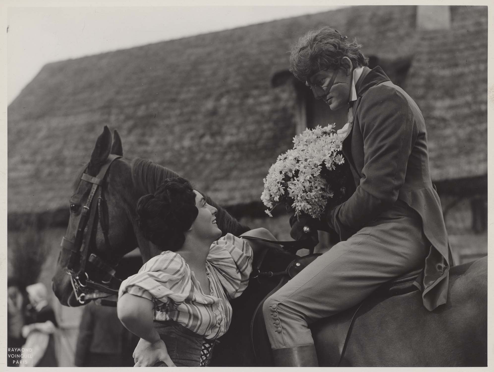 Micheline Gary offrant des fleurs à Jean Marais, à cheval