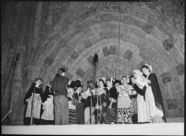 Fête bretonne à Quimper : Chorale de femmes en costumes traditionnels sur scène devant l'entrée de la cathédrale Saint-Corentin