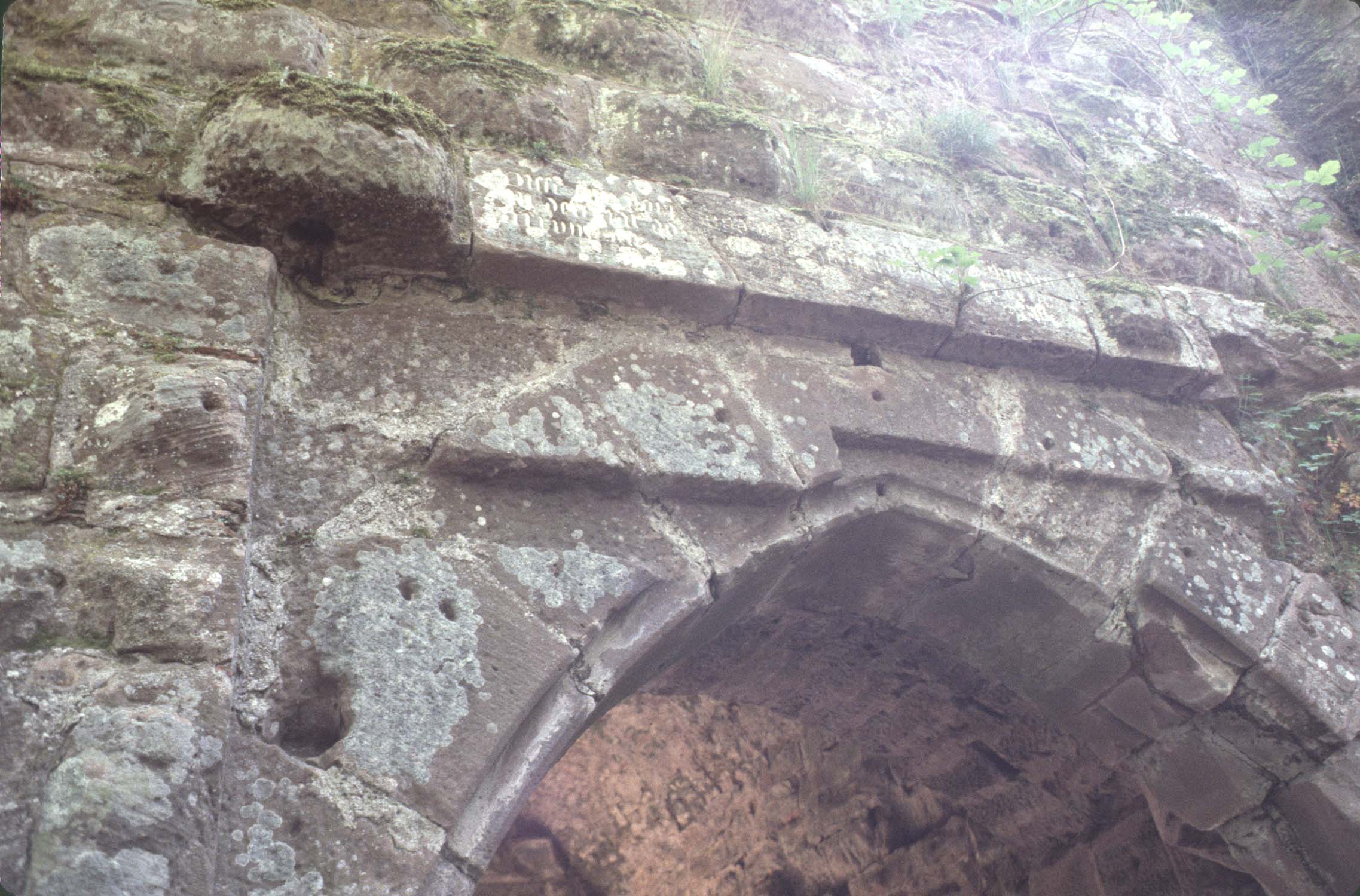 Porte de la basse-cour : ogive et inscription sur le linteau, détail