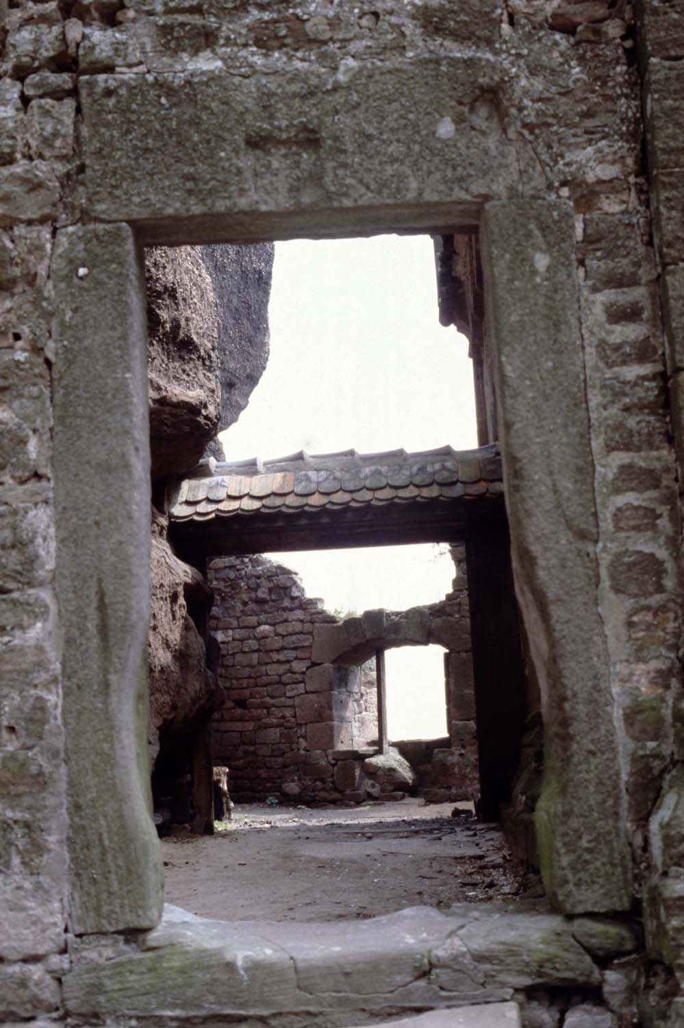 Espace entre la chapelle et le rocher, vue partielle à travers une ouverture