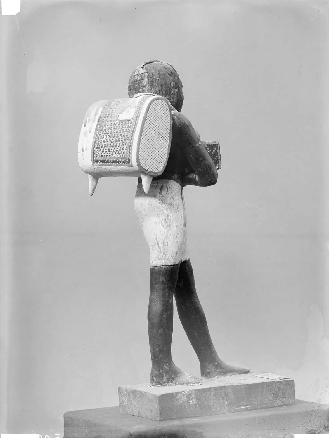 Statuette en bois peint d’un porteur d’offrandes provenant de la tombe de Niankhpepi dit le Noir à Meir : vue de dos