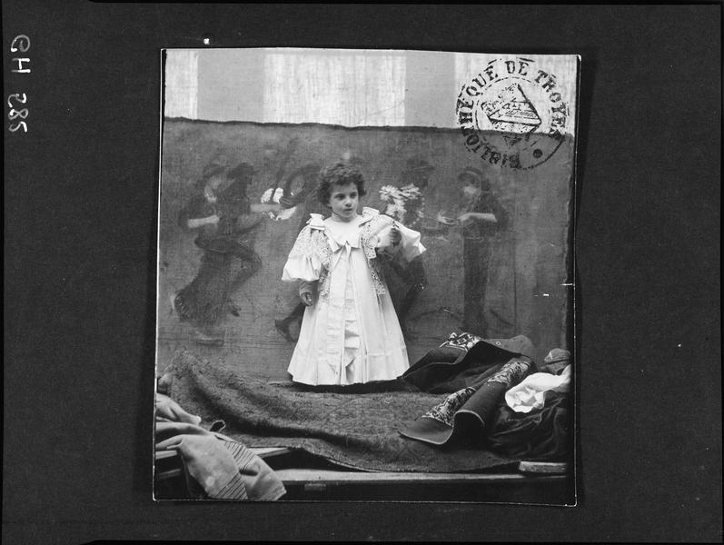 Portrait de Renata, surnommée Cicciuzza, fille de la princesse Maria Gravina Cruyllas di Ramacca et de Gabriele d'Annunzio, posant devant un décor peint