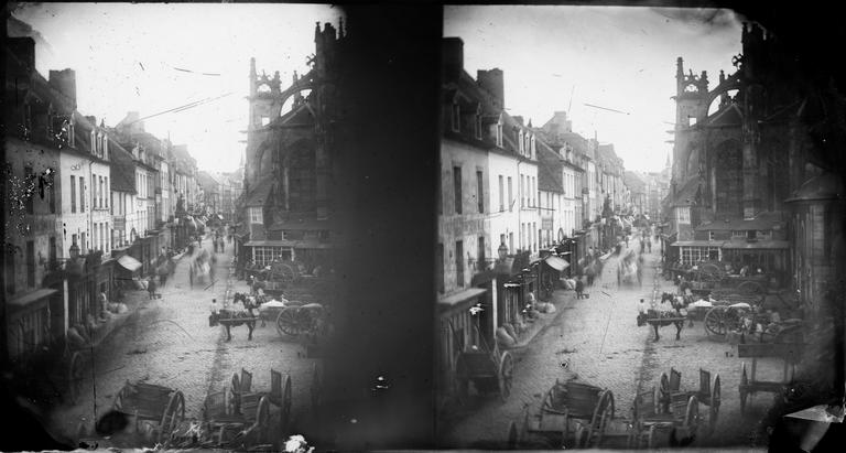 Vue d'une rue animée par des charrettes et l'abside de l'église Saint-Gervais, vue du balcon de l'atelier du photographe