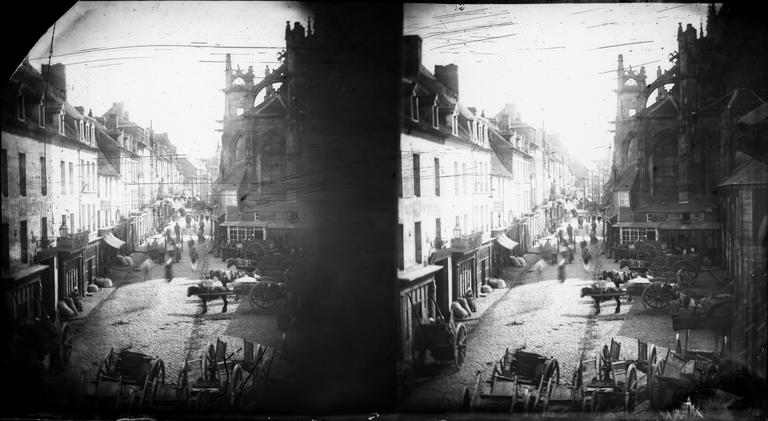 Vue d'une rue animée par des charrettes et l'abside de l'église Saint-Gervais, vue du balcon de l'atelier du photographe