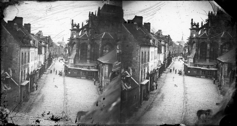 Vue d'une rue peu animée et de l'abside de l'église Saint-Gervais-Saint-Protais