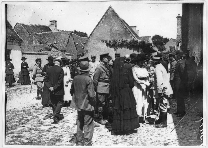 Devant l'église, les officiers français et américains, en robe blanche la marquise de Rochambeau causant avec un officier français, au milieu, les mains derrière le dos, le général américain Taylor